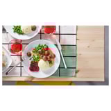 Vervallen dineropstelling met borden, bestek en glazen op houten tafel.