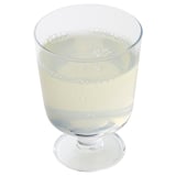 Glass filled with clear, bubbly liquid, likely a sparkling beverage.