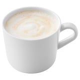 A white mug filled with a creamy foam-topped coffee drink.