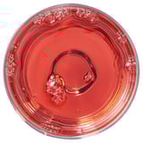 A glass filled with bubbly, reddish liquid, possibly a beverage.