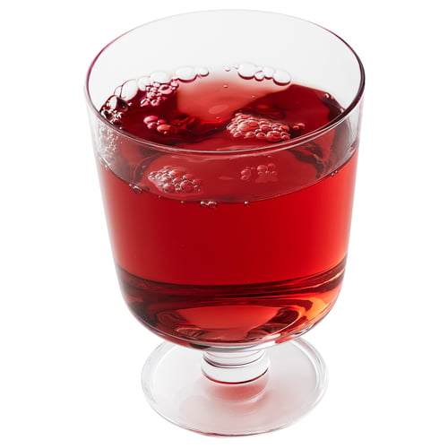 Tasse en verre transparent remplie d’un liquide rouge pétillant, probablement une boisson aromatisée.