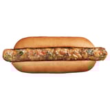 Plne zeleninový hot dog s viditeľnými kúskami zeleniny, podávaný v žemli.