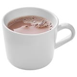 White ceramic mug filled with frothy coffee, perfect for a cozy break.