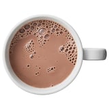 A white mug filled with foamy coffee. A comforting beverage, perfect to enjoy anytime.