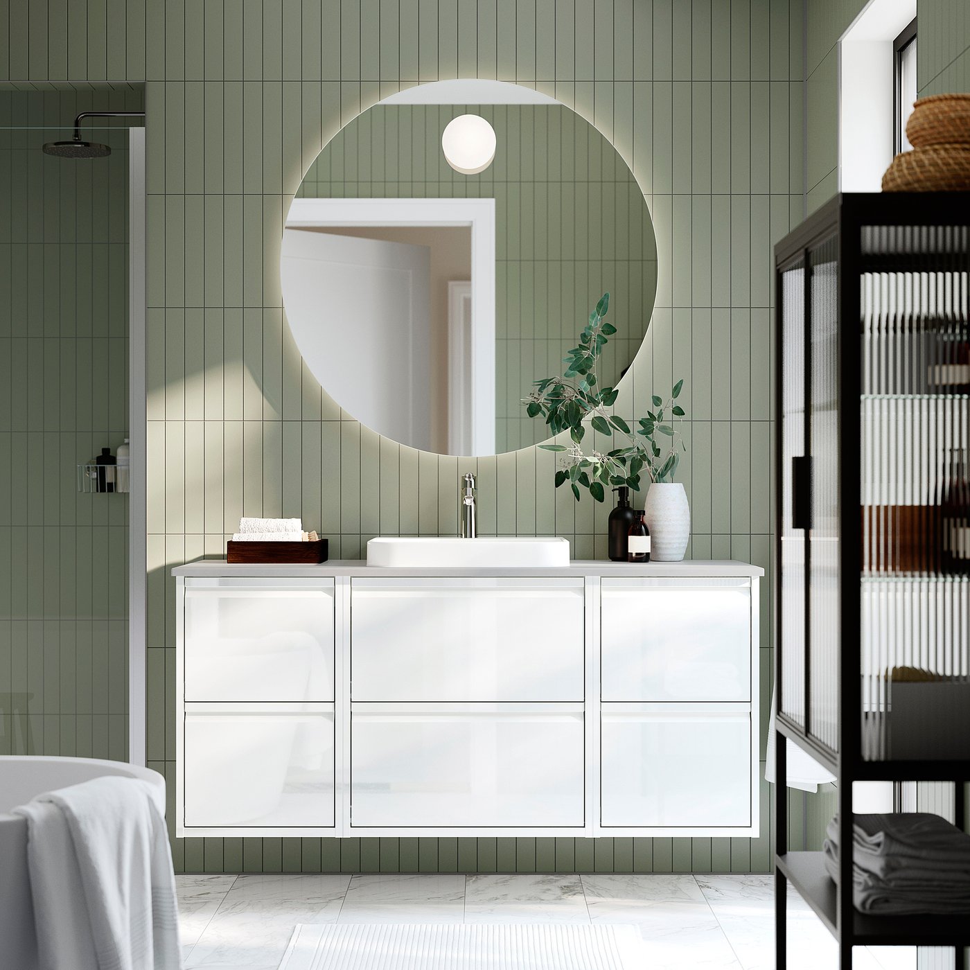 White wall-mounted vanity with mirror, sink, modern tap, drawers, green tiles, black shelves with towels.