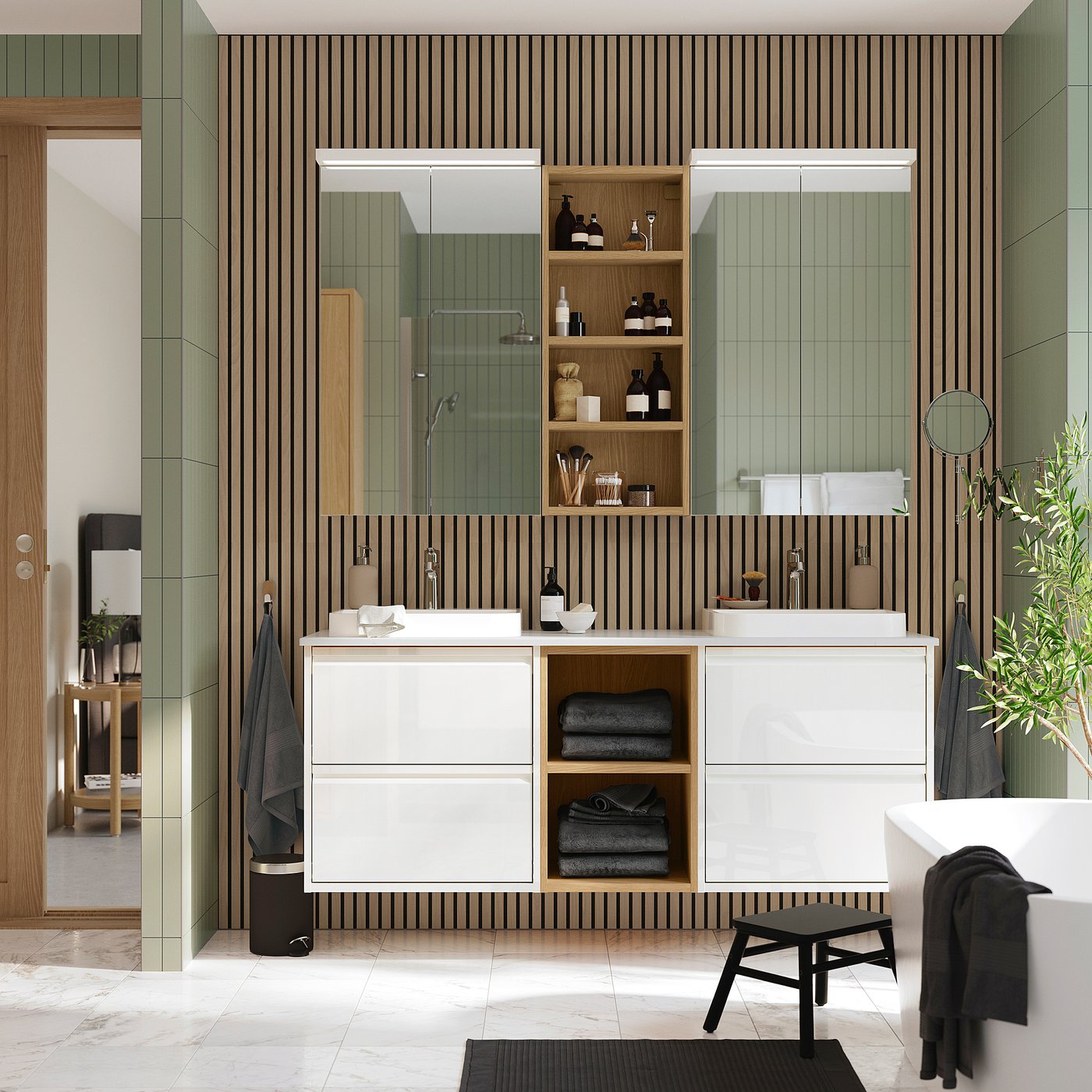 Modern bathroom with green slatted walls, double vanity, black towels, freestanding tub, and vast mirrors.
