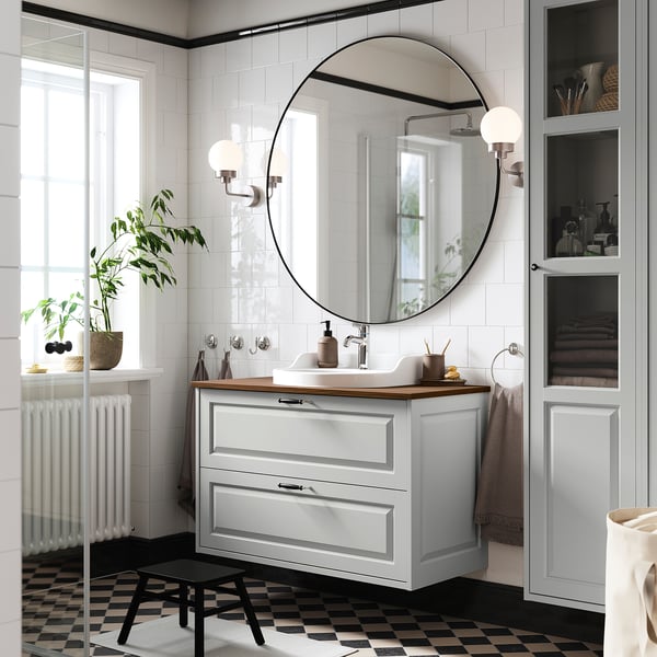 Modern bathroom: TÄNNFORSEN cabinet in light grey. Mirror, sink, plants.