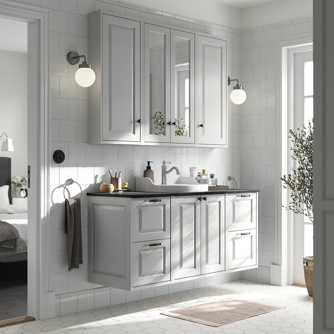 Modern bathroom with light grey TÄNNFORSEN cabinet set, marble counter, wall lamps, and plant.