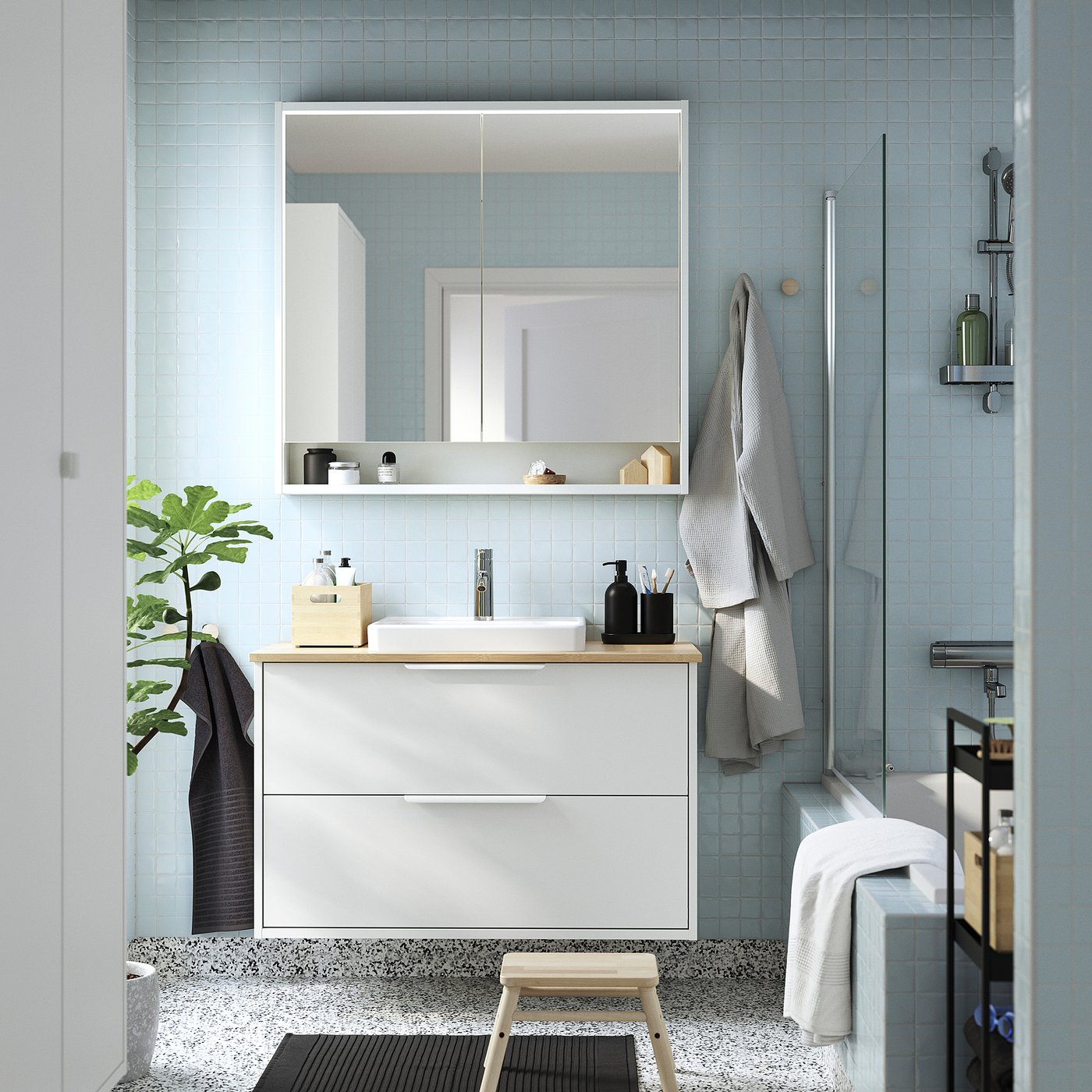 Modern bathroom with HAVBÄCK vanity, clean lines, wooden counter, semi-recessed sink, wall-mounted, blue tiles, glass shower, fresh, serene.