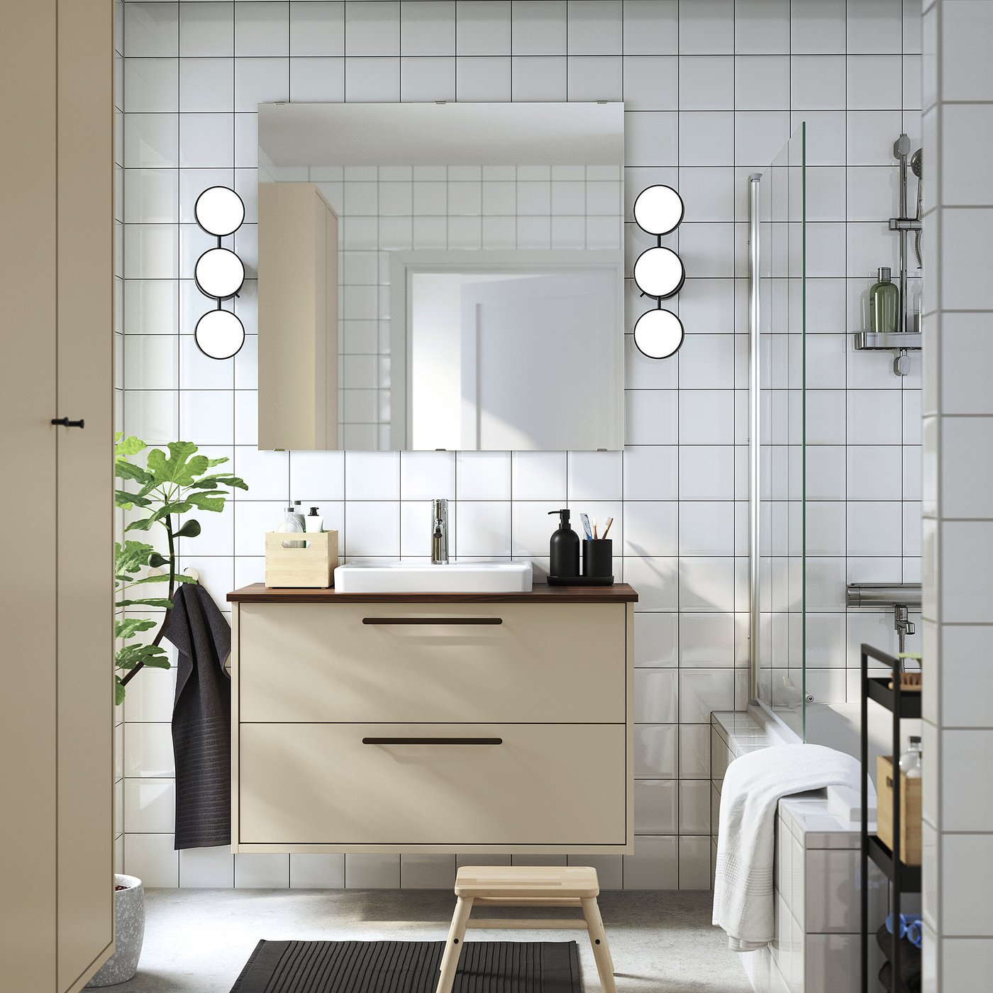 Modern beige bathroom vanity with sleek design, round mirror, plants, and minimalist decor.
