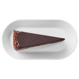 Oval plate with slice of chocolate cake. Rich sponge and buttercream frosting.