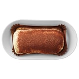 Image depicts a dessert, likely tiramisu, served in a white container. It coffee-flavored ladyfingers and mascarpone filling.