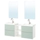 Two modern sage green vanities with white countertops, mirrors, and chrome faucets.