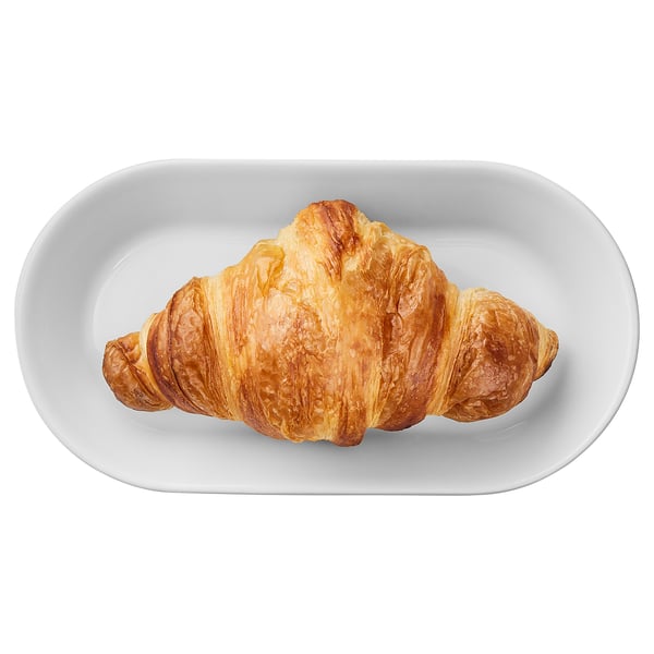 Single croissant on white plate, golden brown, flaky layers.