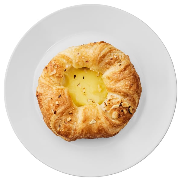 A round pastry with vanilla cream center, golden brown and topped with nuts.