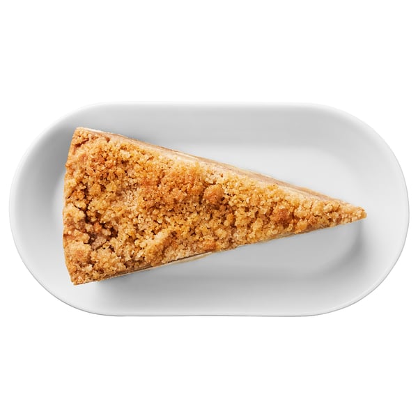 Image shows a triangle-shaped pastry with crumb topping on a white plate. Likely a cinnamon crumb cake.