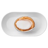 Kleines Mandel-Zitronen-Törtchen mit Glasur auf weißem Teller. Köstlicher schwedischer Leckerbissen.