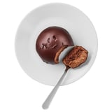 Plate with a chocolate dessert, half-eaten, silver spoon. Rich, dense texture, smooth surface.