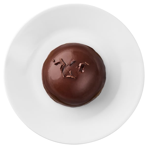 A single chocolate mousse dessert sits on a white plate, featuring rich chocolate flavor with soft and crunchy textures.