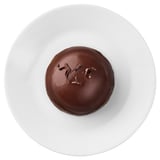 A single chocolate mousse dessert sits on a white plate, featuring rich chocolate flavor with soft and crunchy textures.