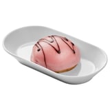White dish holding a pink, round dessert with chocolate swirls.