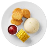 Plant-based meal: crispy breaded pieces, mashed potatoes, corn, and ketchup.