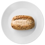 A loaf of bread with seeds on a white plate.