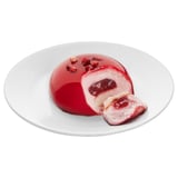 A red raspberry mousse cake, sliced on a white plate, showing soft filling and topped with berry pieces.