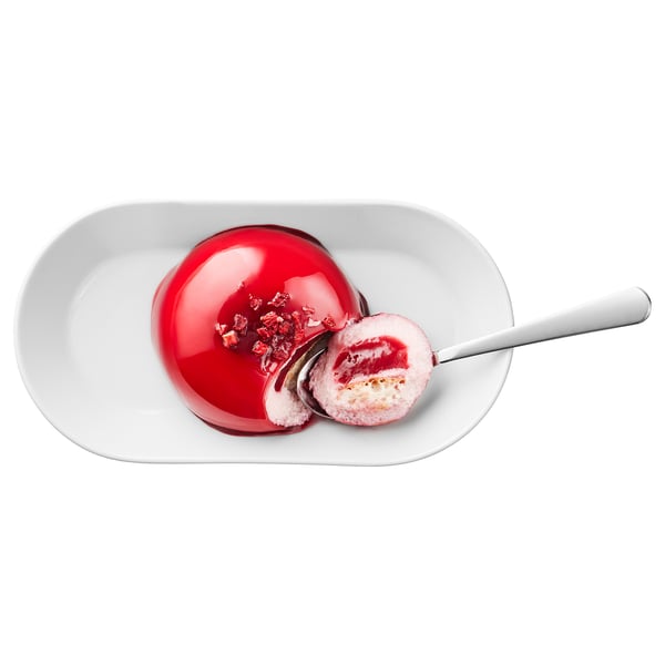 Image shows a dessert: red glaze, raspberry filling, on white plate. Spoon included.