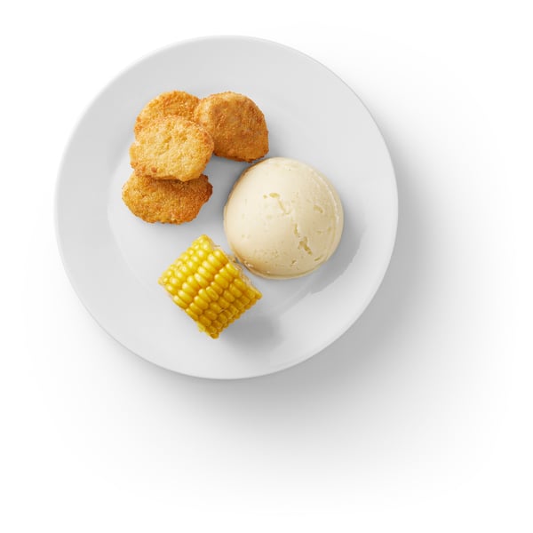 Image a white plate with breaded plant-based food, mashed potatoes, and corn.