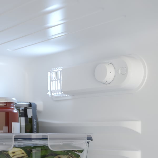 A small fridge interior with shelves and a temperature control panel. Led light illuminates food and adjustable compartments are visible.