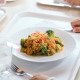 Bol blanc de riz et de légumes. Couleurs vives, forme ronde, sur une table.