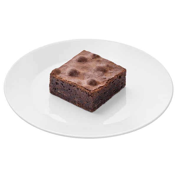 Square chocolate dessert on a white plate. Rich, dense texture, bittersweet flavor.