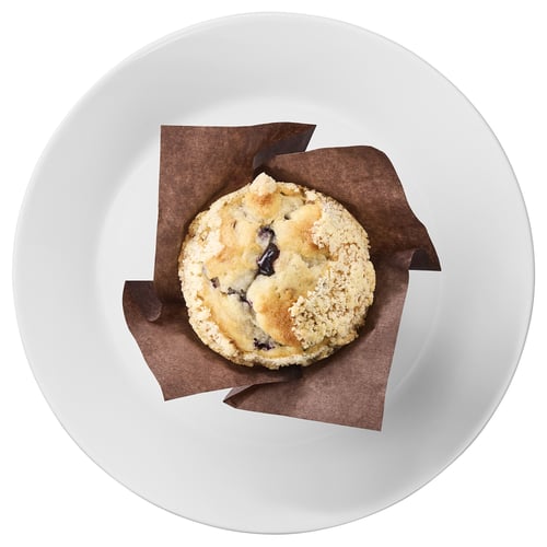 Blueberry muffin sits in paper liner on white plate, ideal for portable snacking.