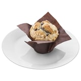 Ein Blaubeer-Muffin in Tulpenpapier auf einem Teller, perfekt für einen schnellen Snack.