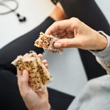 Holding cereal bars with nuts and seeds, ready to eat.
