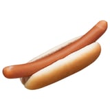 A plain hot dog bun with an uncooked sausage in it, no toppings.