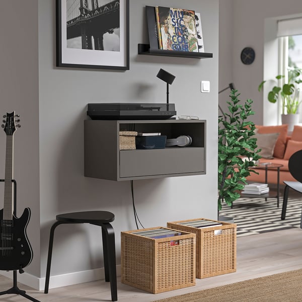 Modern living room with black EKET storage, records, guitar, plants.