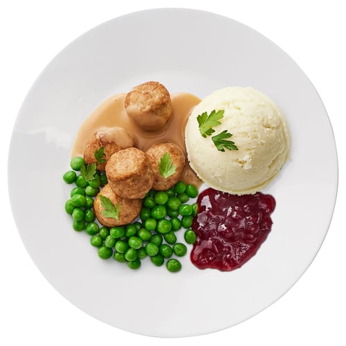 White plate with chicken meatballs, peas, mashed potatoes, and cranberry sauce.