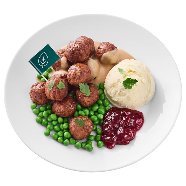 A plate of meatballs, mashed potatoes, peas, and cranberry sauce.