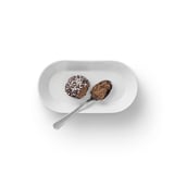 Un piatto bianco con due cucchiaiate di dessert al cioccolato e scaglie di cocco.