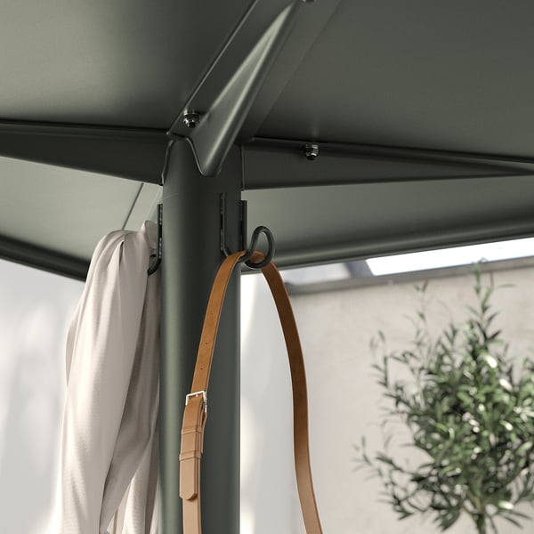 Image description: a white cloth and a tan belt hang from hooks under a gray outdoor table, showcasing the VISINGSÖs functional storage.