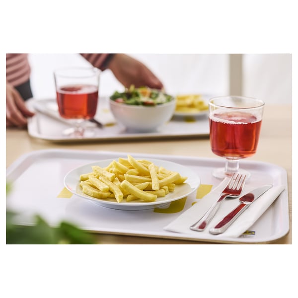 Weißes Tablett mit gelben Pommes, rotem Getränk, silberner Gabel und Messer.