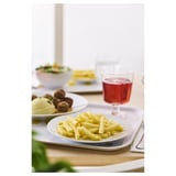 Ein Esstisch mit Tellern mit Essen und einem Glas rotem Getränk.