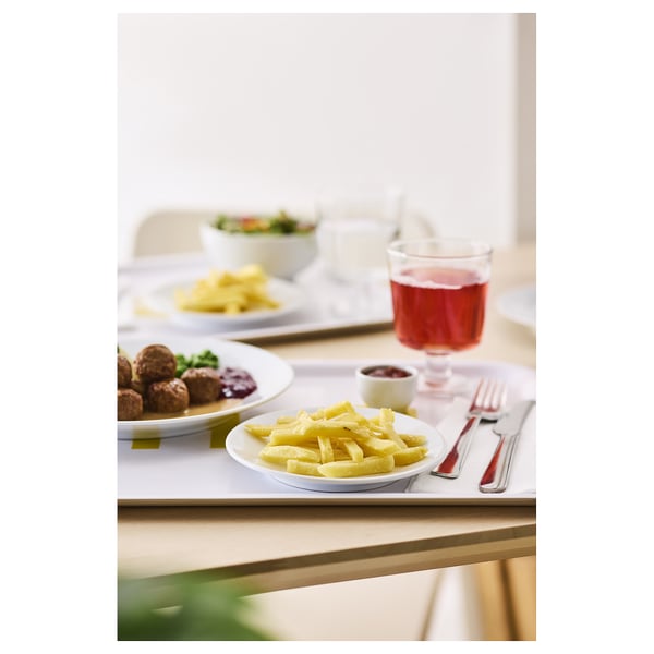 A meal setup on a table with plates of food, a glass of red juice, and cutlery.