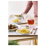 A meal setup on a table with plates, cutlery, and a glass.