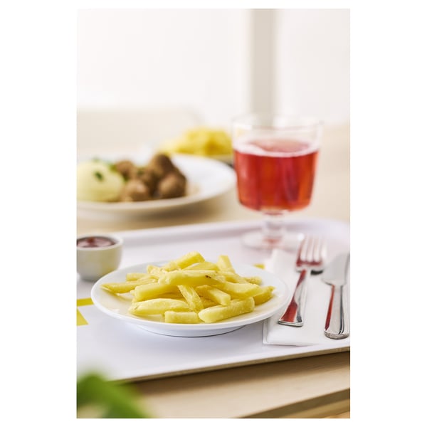 Plate of yellow fries beside a red drink.