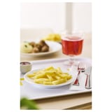 Plate of yellow fries beside a red drink.