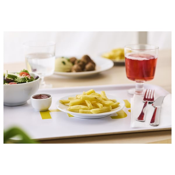A dining setup with white plates, red cutlery, and food.