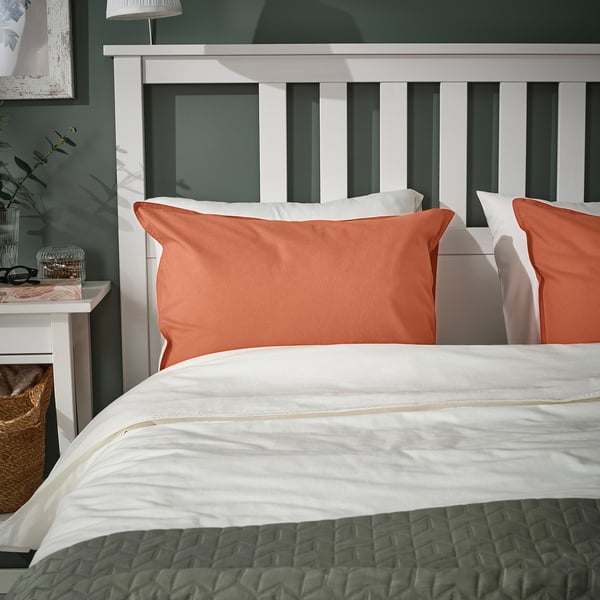 Poszewka na poduszkę ÄNGSLILJA rdzawopomarańczowa, miękka bawełna, pasuje na standardową poduszkę, na przytulne łóżko, z białą pościelą, koszem i szafką nocną.